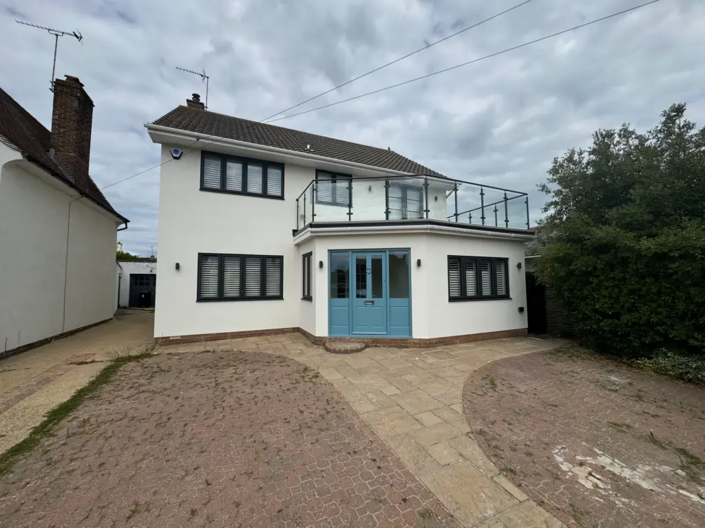 Original weathered block paved driveway before renovation in Frinton-on-Sea, with weeds through the joints