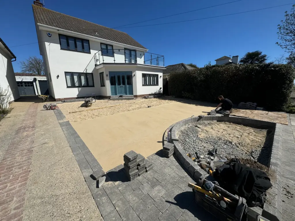 Sharp sand screed and block edging around the circular planting bed during a block paving installation in Frinton-on-Sea