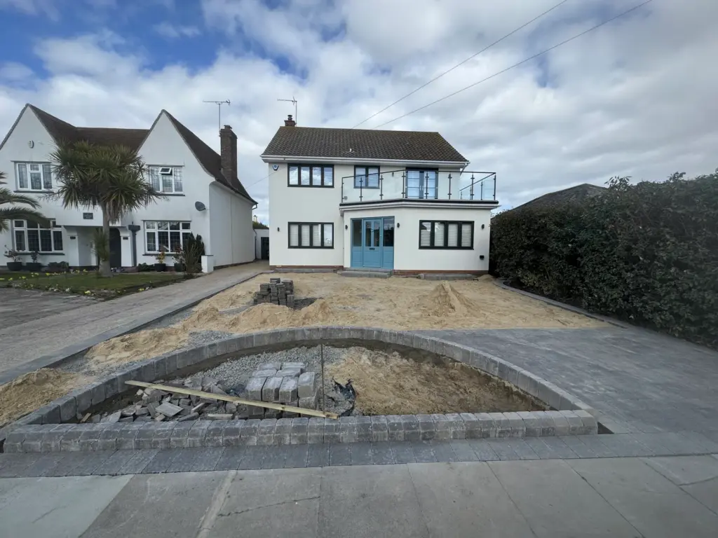 Circular planting bed edging being laid on the compacted base during a block paved driveway installation in Frinton-on-Sea