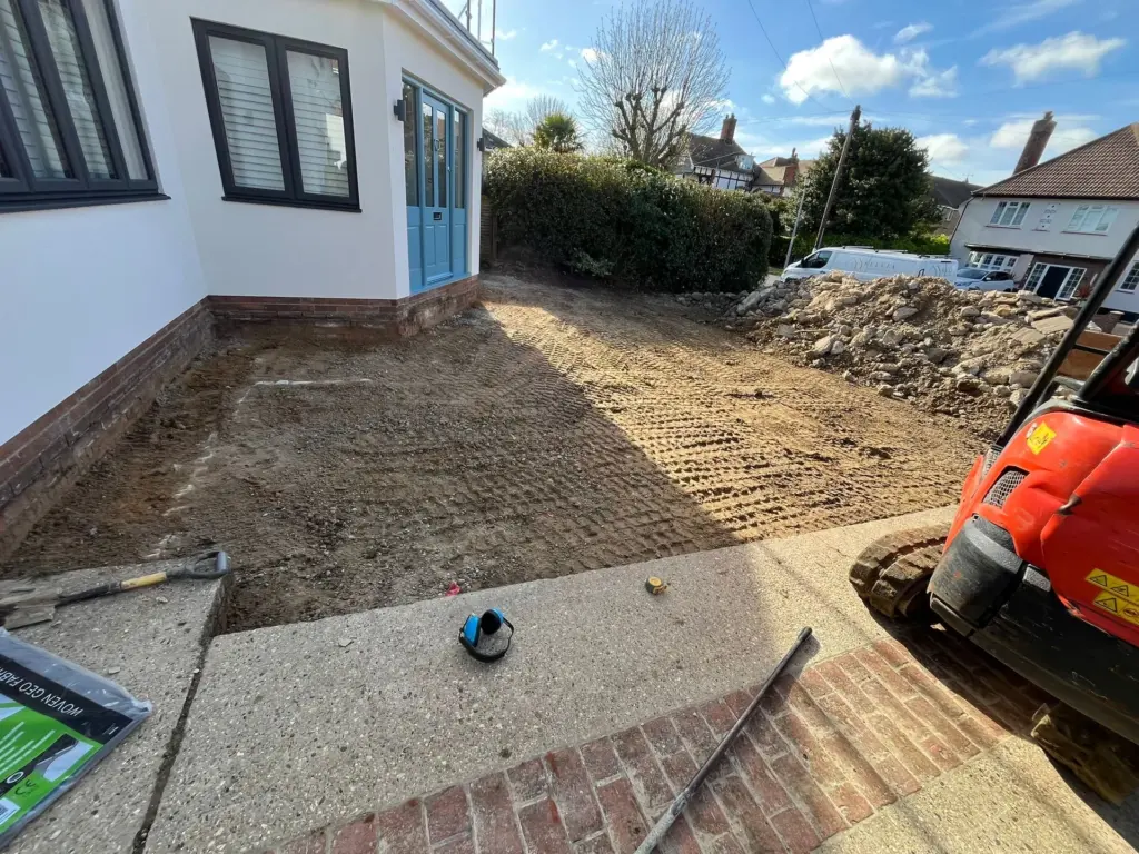 Excavation continuing on a Frinton-on-Sea driveway project, spoil pile and geotextile membrane ready ahead of the sub-base