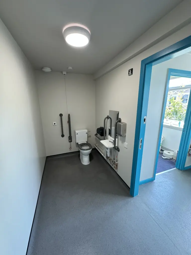 Completed accessible WC interior at The Hawthorns School in Chelmsford with grab rails and a low-level basin