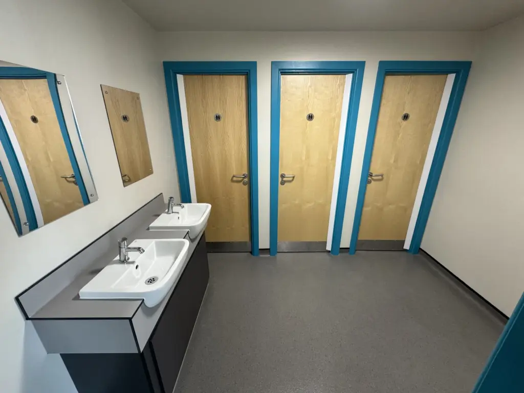 Completed school washroom in Chelmsford showing the cubicle doors and new handwashing area
