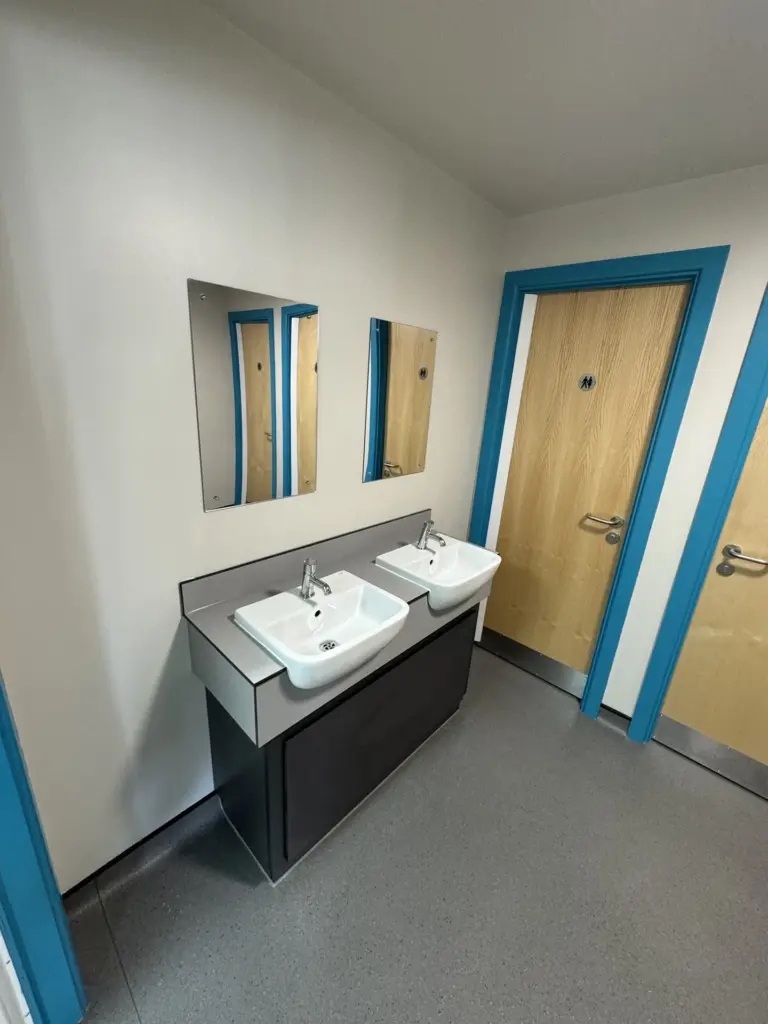 Low-level vanity unit and taps in the completed washroom at The Hawthorns School in Chelmsford