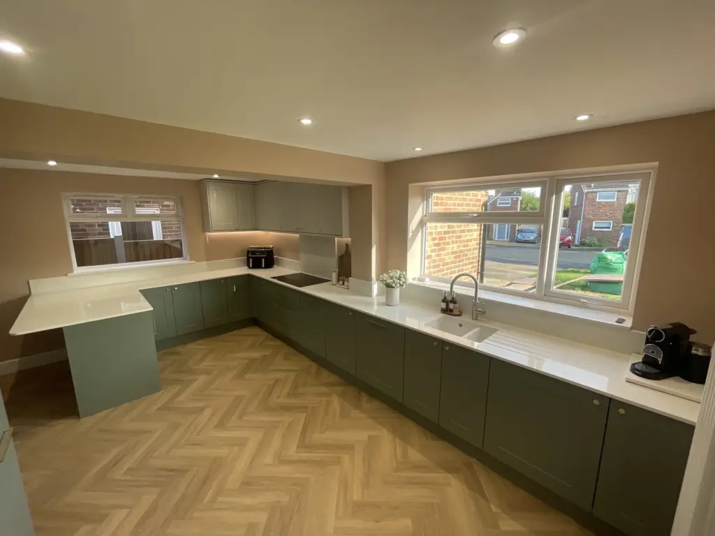 Completed kitchen in a Kelvedon double storey side extension with green cabinetry and herringbone flooring