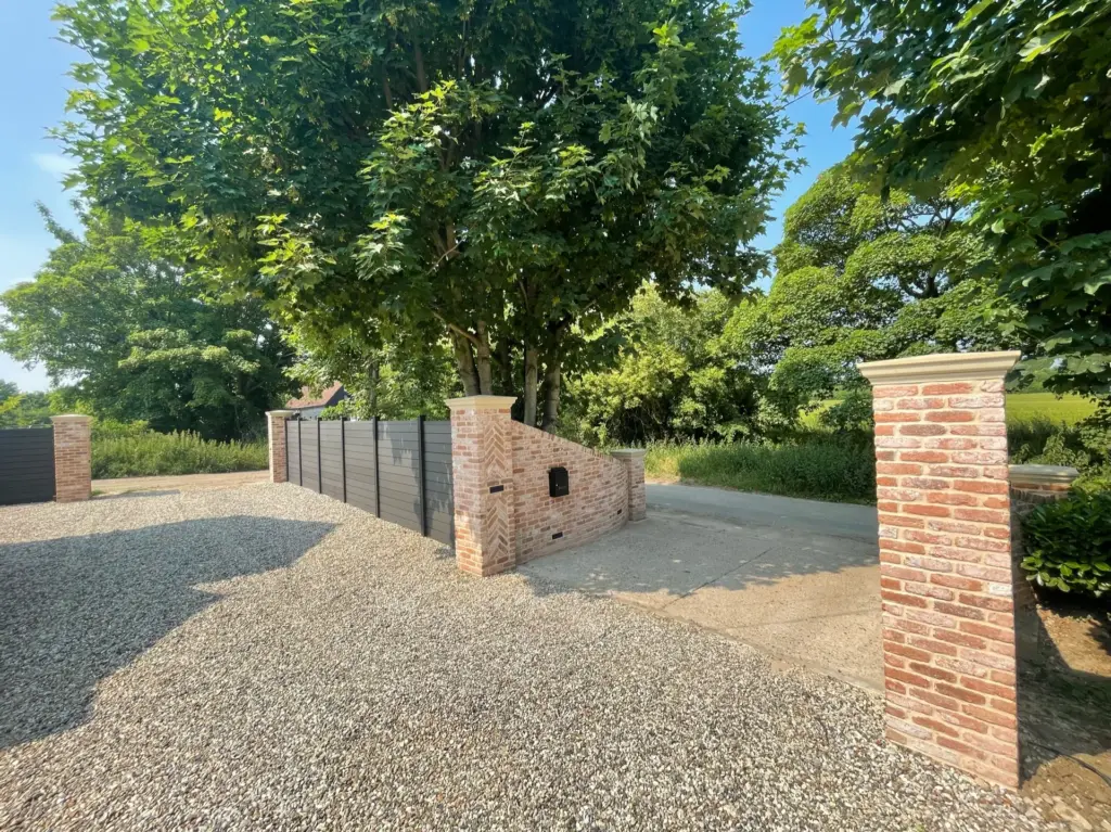 Completed front boundary with shingle parking, brick piers and composite fencing in Rivenhall