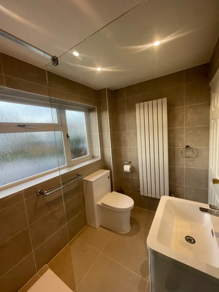 Completed bathroom in Tiptree with a walk-in shower, vanity unit and toilet