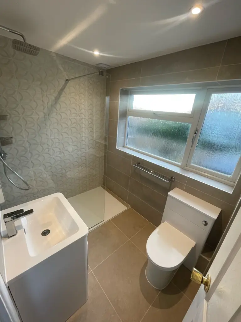 Completed Tiptree bathroom with a vanity unit, toilet and tiled feature wall