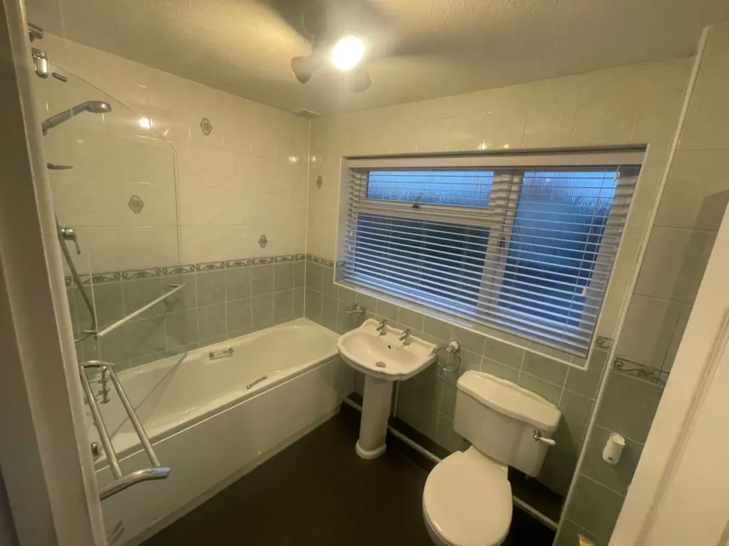 Original bathroom in Tiptree before the full refurbishment, with bath, pedestal basin and green wall tiles