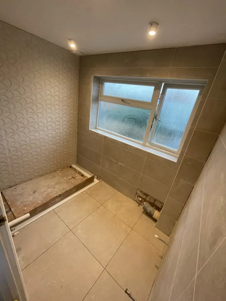 Wall and floor tiling in progress during a bathroom installation in Tiptree