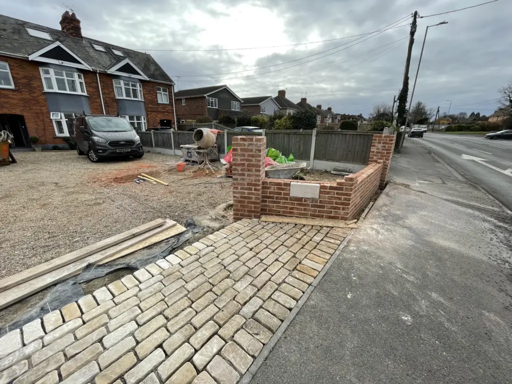 Part-built brick entrance wall viewed from the road in Witham