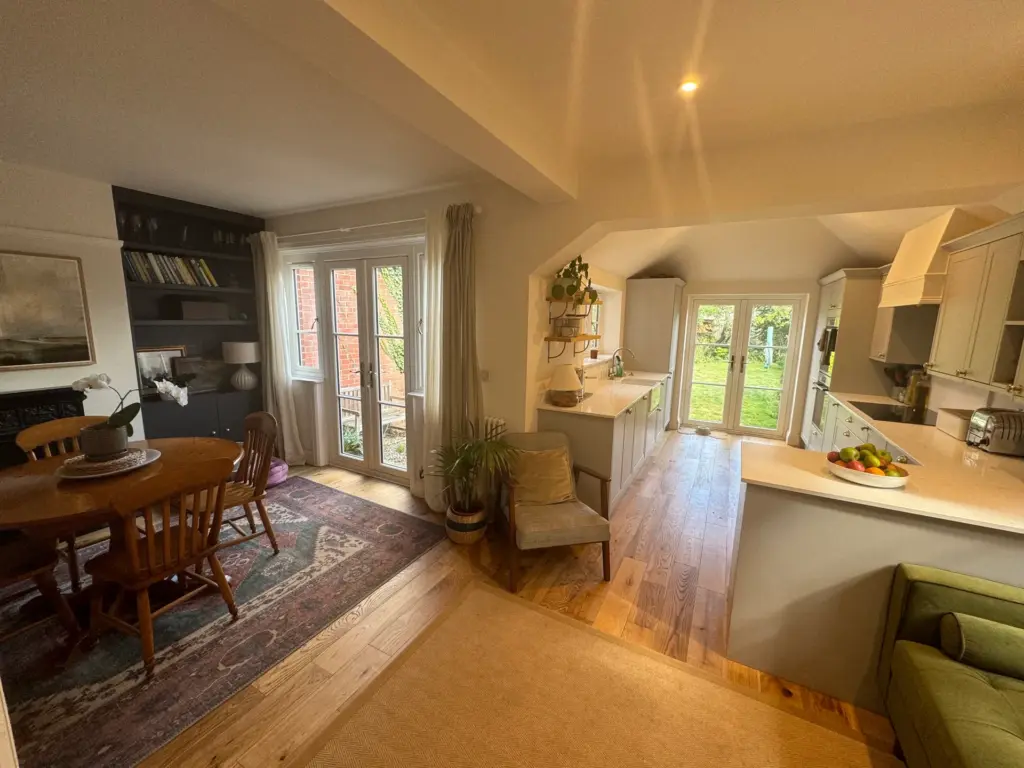 Completed L-shaped kitchen, dining and living space in Witham with French doors onto the garden