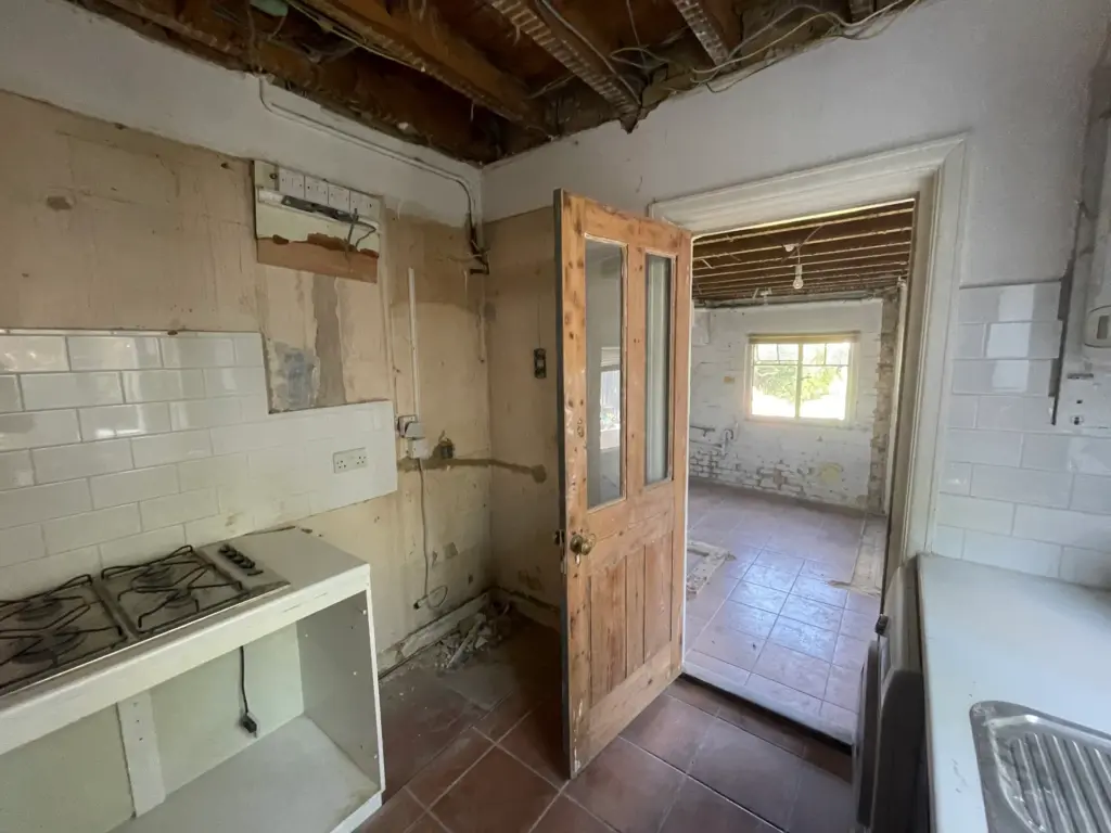 Stripped kitchen wall in this Witham property showing exposed brickwork ahead of the refurbishment