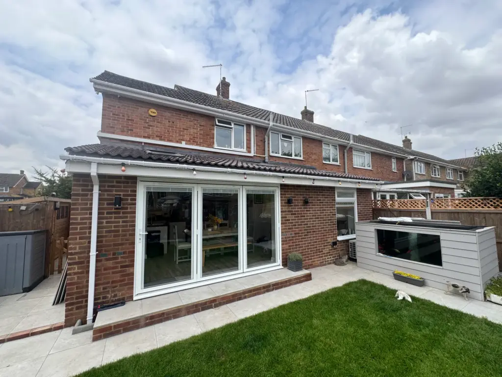 Side view of the completed single storey rear extension in Writtle, showing the tiled lean-to roof, roof windows and white bi-fold doors