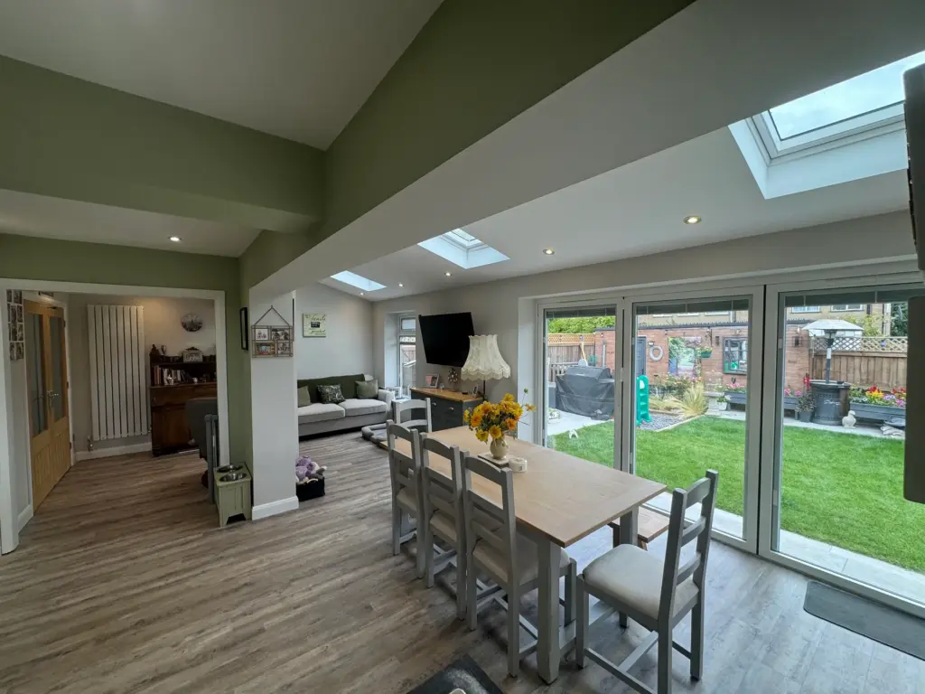 Dining area of the furnished Writtle extension with full-width aluminium bi-fold doors opening onto the garden